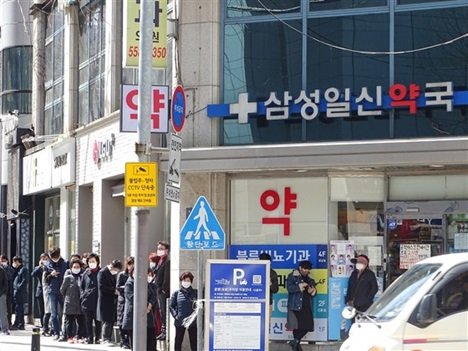 Ludzie czekają przed apteką w południowym Seulu, aby kupić cotygodniowe racje dwóch masek