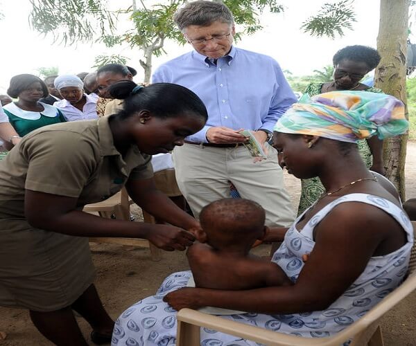 Autor patrzy na pracownika służby zdrowia, który szczepi dziecko, Dystrykt Awutu Senya, Ghana, Marzec 2013.